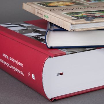 Stapel Bücher vor grauem Hintergrund mit Fadenbindung